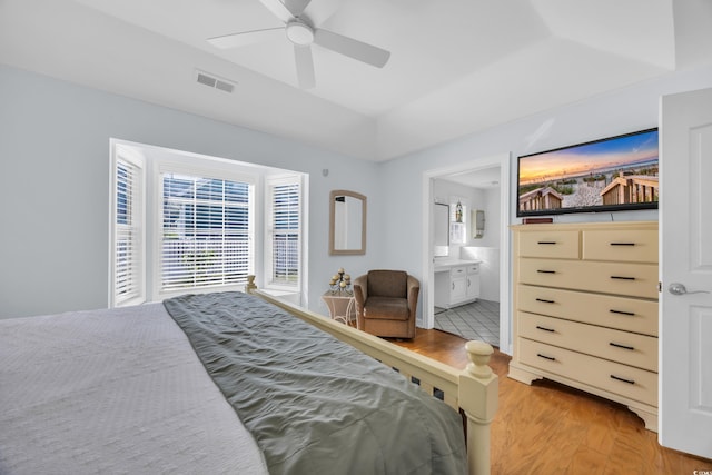 bedroom with connected bathroom, light wood-type flooring, visible vents, ceiling fan, and lofted ceiling