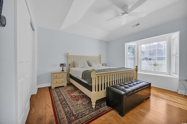 bedroom featuring ceiling fan, a closet, visible vents, and wood finished floors