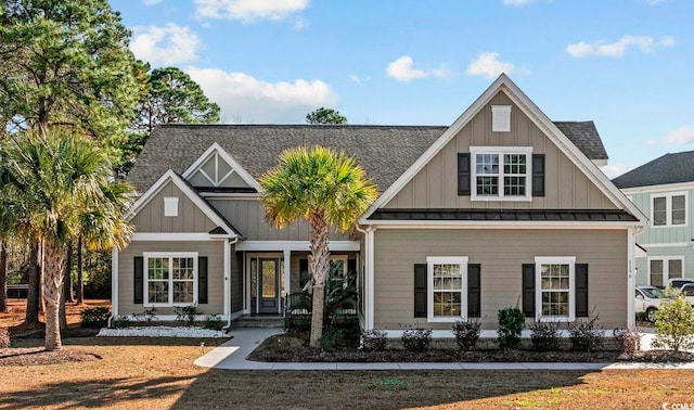 craftsman-style home with a shingled roof, board and batten siding, a standing seam roof, covered porch, and metal roof