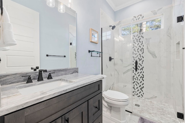 bathroom featuring crown molding, vanity, toilet, marble finish floor, and a marble finish shower