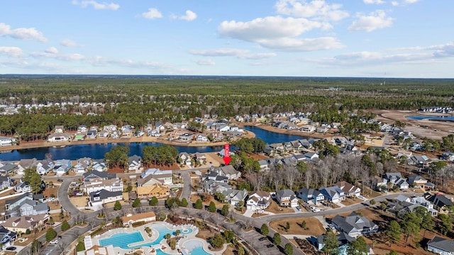 bird's eye view with a water view, a view of trees, and a residential view