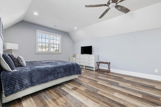 bedroom with ceiling fan, wood finished floors, and lofted ceiling