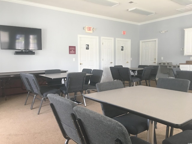 dining area with crown molding and light carpet