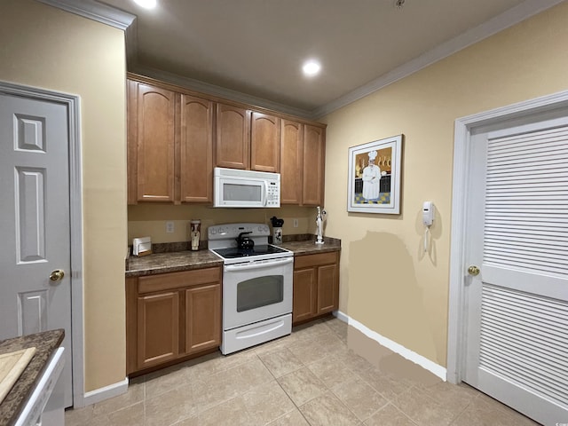 kitchen with crown molding, dark countertops, brown cabinets, baseboards, and white appliances