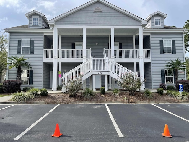 view of property featuring uncovered parking and stairway