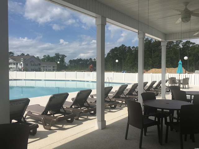 pool with ceiling fan and fence