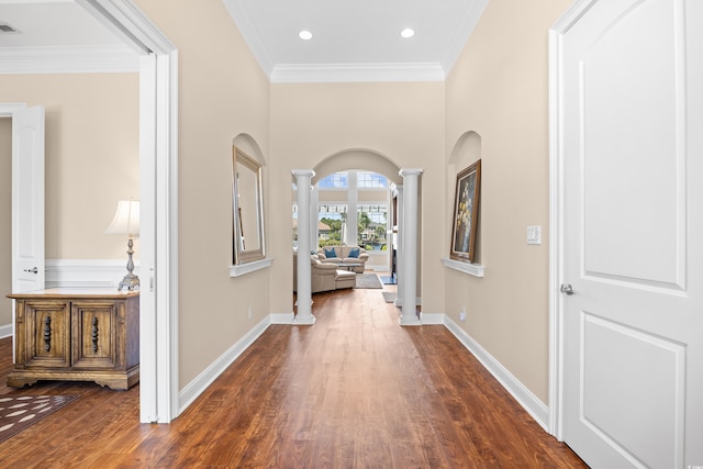 hall featuring ornate columns, arched walkways, ornamental molding, and dark wood-type flooring