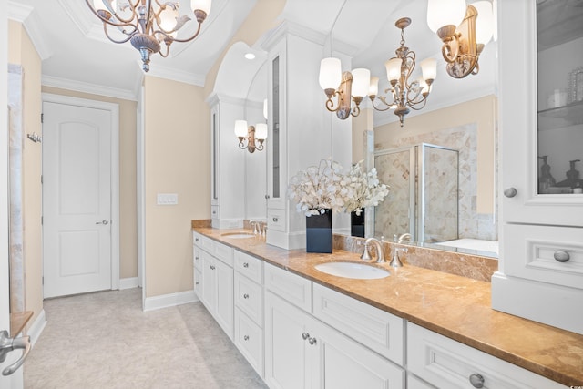full bath featuring an inviting chandelier, double vanity, a shower stall, and a sink