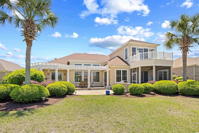 back of property featuring a patio, a balcony, a yard, a pergola, and stucco siding