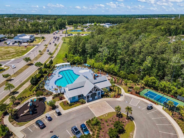 birds eye view of property featuring a water view and a wooded view