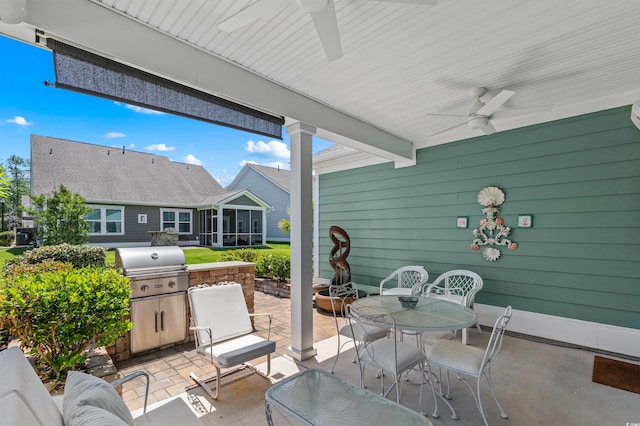 view of patio with a sunroom, a ceiling fan, a grill, and outdoor dining space