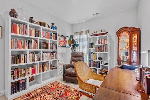 living area with visible vents and carpet