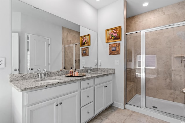 full bathroom featuring double vanity, visible vents, a sink, and a stall shower