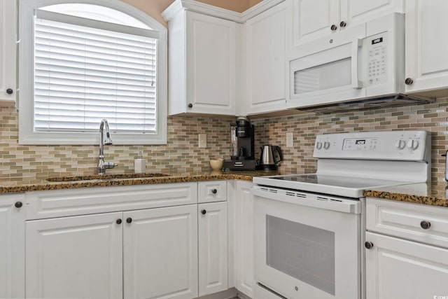kitchen with white appliances, a sink, backsplash, and white cabinets
