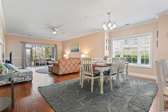 dining area featuring hardwood / wood-style floors, a chandelier, a ceiling fan, ornamental molding, and baseboards