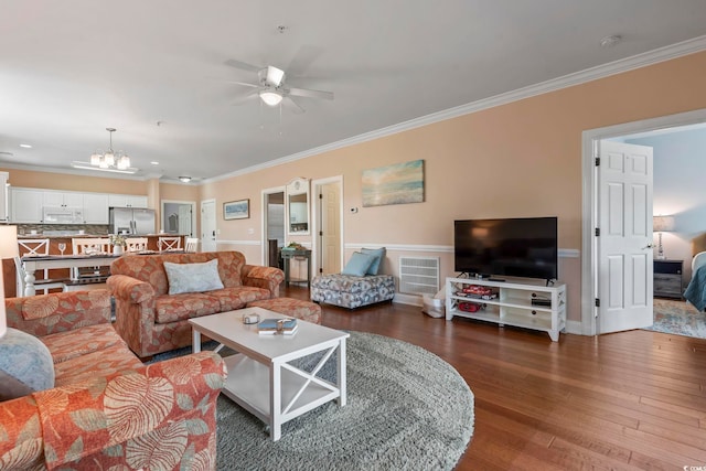 living room with ornamental molding, a ceiling fan, a chandelier, and wood-type flooring