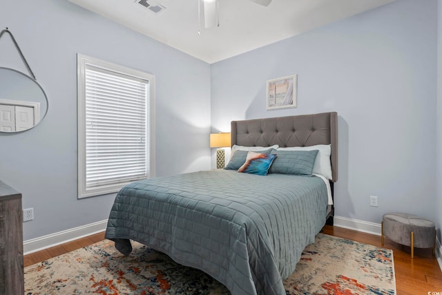 bedroom featuring wood finished floors, baseboards, and ceiling fan