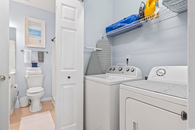 laundry area with washing machine and dryer, light tile patterned floors, and baseboards