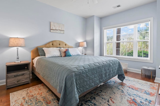 bedroom featuring baseboards, wood finished floors, and a ceiling fan