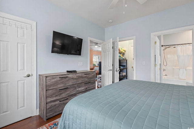 bedroom with dark wood-style flooring, a ceiling fan, and connected bathroom