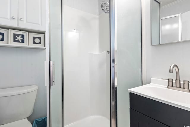 bathroom with vanity, a shower stall, and toilet