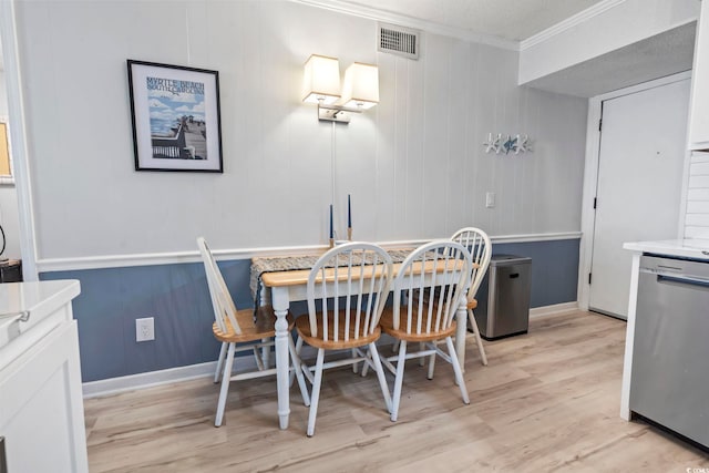 dining space featuring crown molding, visible vents, and light wood finished floors