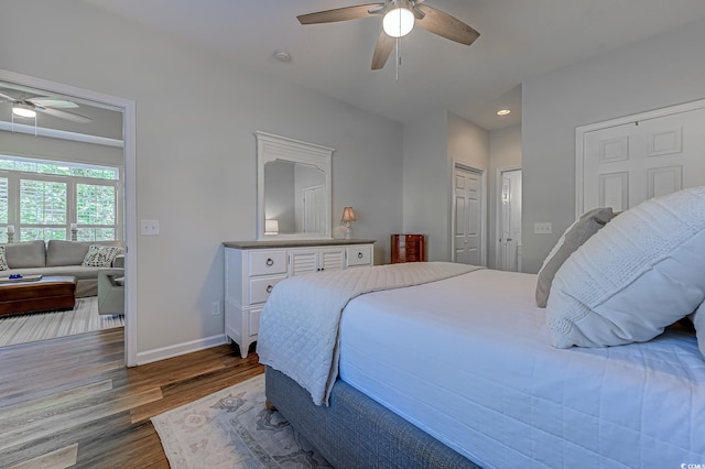 bedroom with multiple closets, wood finished floors, baseboards, ceiling fan, and recessed lighting