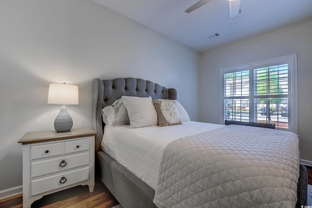 bedroom with a ceiling fan, dark wood-style floors, and visible vents