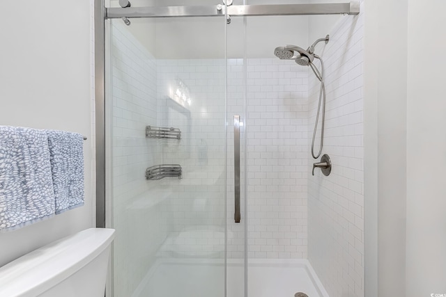 bathroom featuring a shower stall and toilet