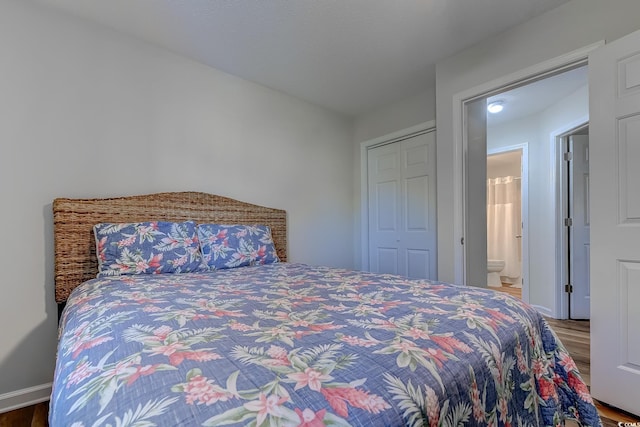 bedroom featuring connected bathroom, baseboards, and wood finished floors