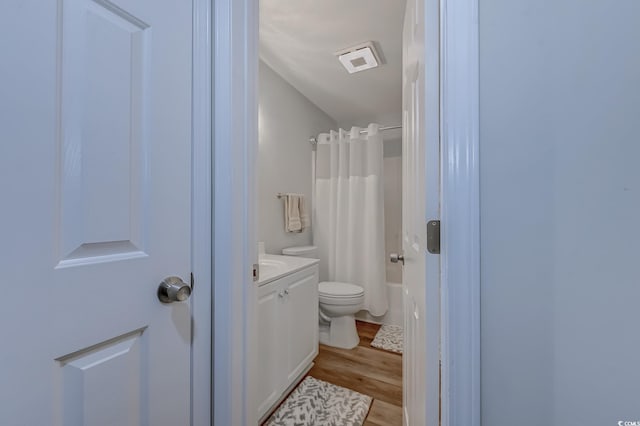 full bath featuring vanity, toilet, wood finished floors, and shower / bath combination with curtain