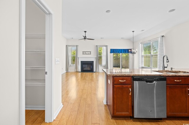 962 Witherbee Way, Little River, SC 29566 - kitchen featuring ceiling fan, light stone countertops, a sink, dishwasher, and a glass covered fireplace