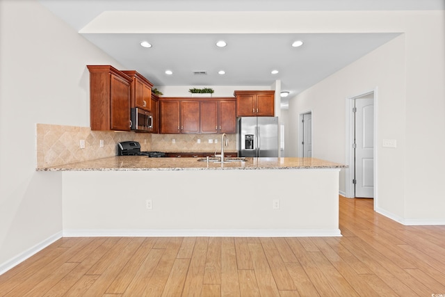 962 Witherbee Way, Little River, SC 29566 - kitchen with light stone countertops, appliances with stainless steel finishes, a sink, a peninsula, and backsplash