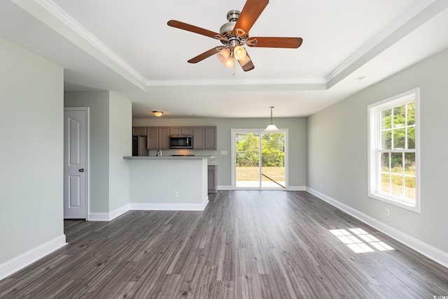 469 Overcrest St, Myrtle Beach, SC 29579 - unfurnished living room with a tray ceiling, crown molding, dark wood-style flooring, and ceiling fan