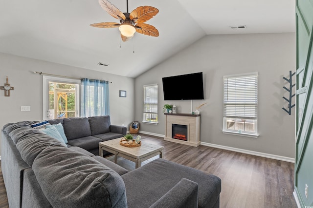 living room featuring a glass covered fireplace, dark wood finished floors, a ceiling fan, vaulted ceiling, and visible vents