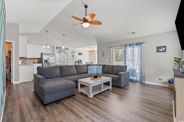living room featuring a ceiling fan, baseboards, lofted ceiling, dark wood-type flooring, and visible vents