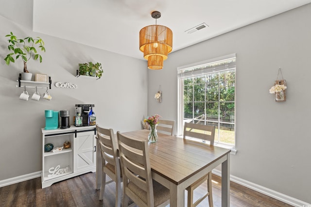 dining area featuring dark wood-type flooring, baseboards, a chandelier, and visible vents