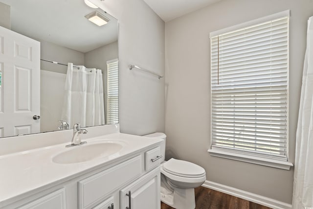 bathroom with visible vents, wood finished floors, baseboards, vanity, and toilet