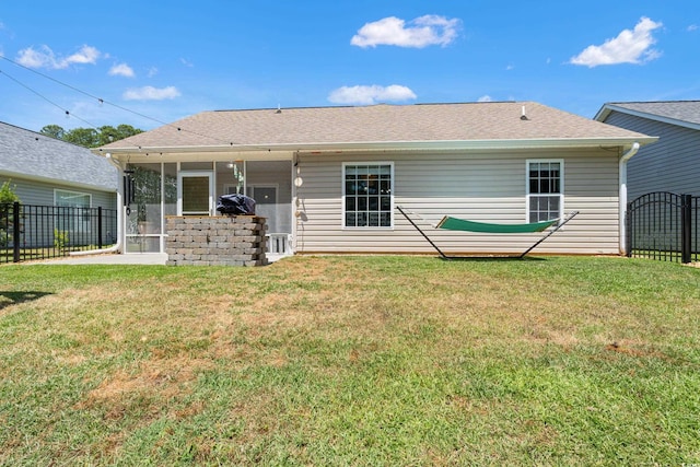 back of house with a sunroom, a lawn, and fence