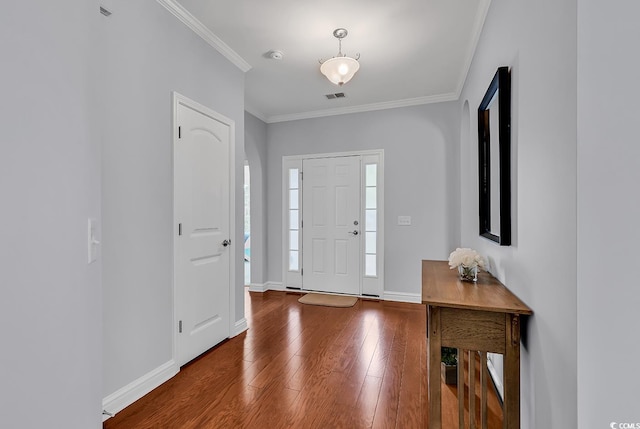 entryway featuring wood-type flooring, ornamental molding, baseboards, and visible vents