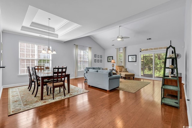 living area featuring visible vents, ceiling fan with notable chandelier, wood finished floors, and a healthy amount of sunlight