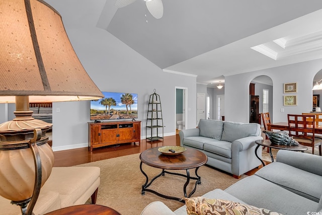 living area with crown molding, ceiling fan, arched walkways, baseboards, and wood finished floors