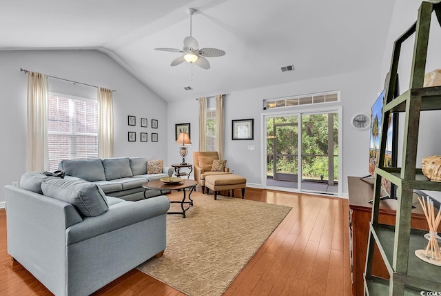 living area featuring ceiling fan, visible vents, wood finished floors, and lofted ceiling