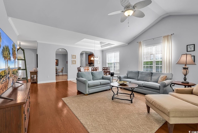 living room with wood-type flooring, baseboards, arched walkways, ceiling fan with notable chandelier, and vaulted ceiling