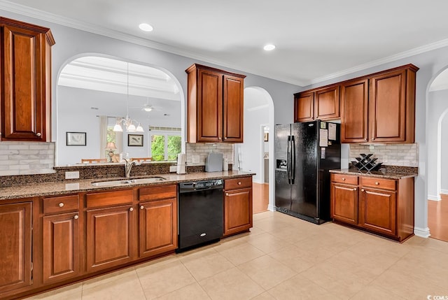 kitchen featuring a sink, arched walkways, backsplash, and black appliances