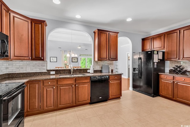 kitchen with decorative backsplash, ornamental molding, arched walkways, a sink, and black appliances