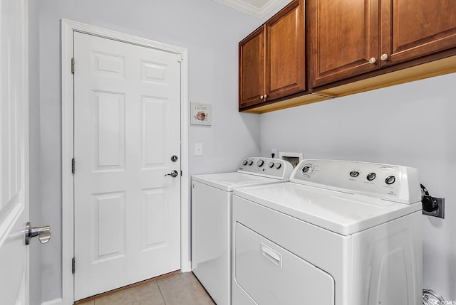 laundry area featuring cabinet space, light tile patterned flooring, crown molding, and washing machine and clothes dryer