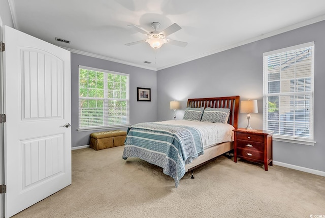carpeted bedroom featuring baseboards, ornamental molding, a ceiling fan, and visible vents