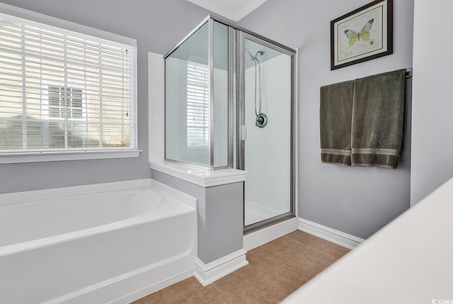 full bathroom featuring tile patterned floors, a shower stall, baseboards, and a bath
