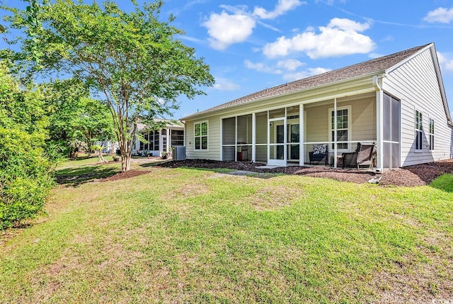 back of house with a sunroom and a lawn